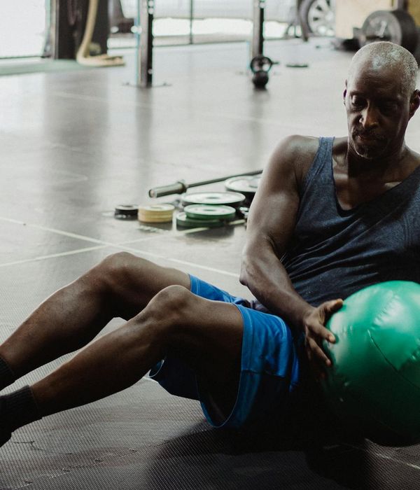 Man performing core strength exercises with focused expression in gym